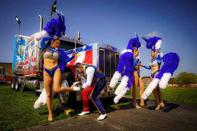 Circus clown Edy helps check the showgirls after fitting their headdress and feather boas as performers prepare for a weekend matinee show at Circus Vegas at Elm Park, Filton, Bristol on Sunday, April 24, 2022. (Photo by Ben Birchall/PA Wire)