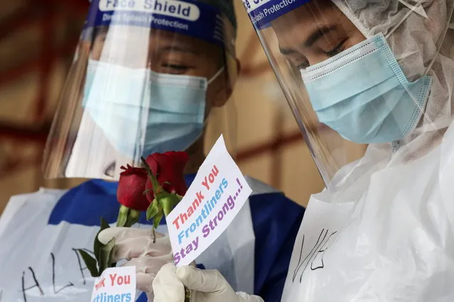 Medical workers hold roses given by members of the public at a coronavirus disease (COVID-19) testing centre in Petaling Jaya, Malaysia on January 25, 2021. (Photo by Lim Huey Teng/Reuters)