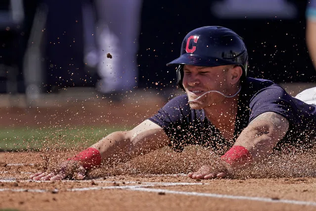 Cleveland Indians Jake Bauers slides home to score on a double by Josh Naylor during the first inning of a spring training baseball game against the Seattle Mariners Tuesday, March 2, 2021, in Peoria, Ariz. (Photo by Charlie Riedel/AP Photo)