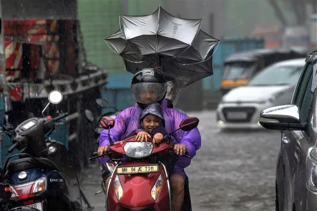 Motorists ride through a rain in Mumbai, India, Sunday, July 2, 2023. India's monsoon season runs June to September. (Photo by Rafiq Maqbool/AP Photo)