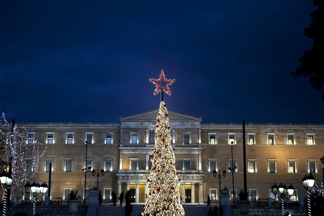 An illuminated Christmas tree is displayed on central Syntagma square as the parliament building is seen in the background in Athens, Greece, December 4, 2015. (Photo by Alkis Konstantinidis/Reuters)