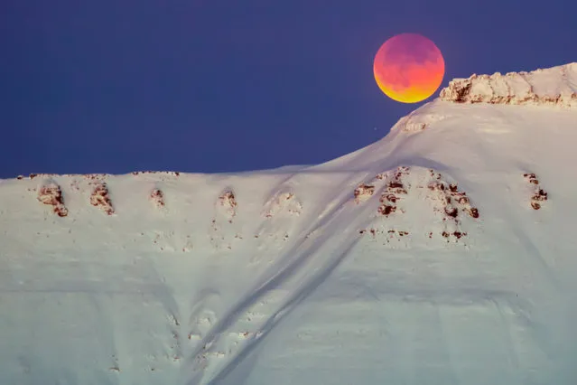 A super blue blood moon behind a mountain is seen from Longyearbyen, Svalbard, Norway, on January 31, 2018. (Photo by Heiko Junge/AFP Photo/NTB Scanpix)