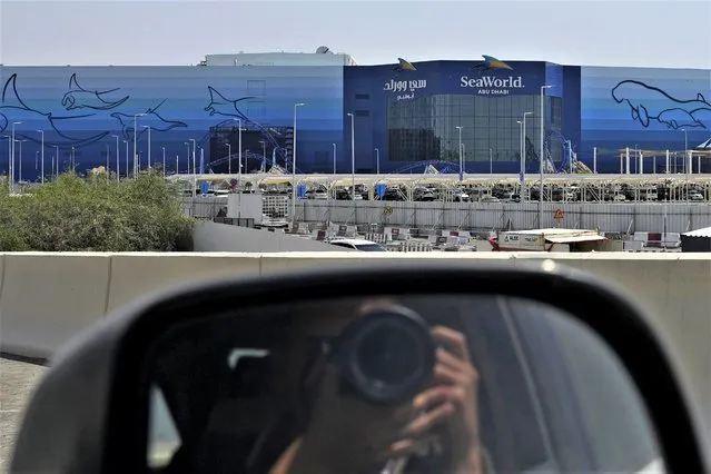 A photographer takes a picture of SeaWorld at the Yas Island in Abu Dhabi, United Arab Emirates, on May 26, 2023. A decade after the outcry over its treatment of captive killer whales nearly put SeaWorld out of business, the company has opened a massive new marine life park in the United Arab Emirates, its first venture outside the United States. A $1.2 billion venture with state-owned developer Miral features the world's largest aquarium and cylindrical LED screen, as well as state-of-the-art facilities housing dolphins, seals, and other animals. (Photo by Nick ElHajj/AP Photo)