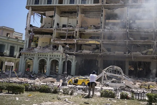 A photographer documents the five-star Hotel Saratoga after it was destroyed by a deadly explosion in Old Havana, Cuba, Friday, May 6, 2022. A powerful explosion apparently caused by a natural gas leak killed at least 18 people, including a pregnant woman and a child, and injured dozens Friday when it blew away outer walls from the luxury hotel in the heart of Cuba’s capital. (Photo by Ramon Espinosa)n Espinosa/AP Photo)