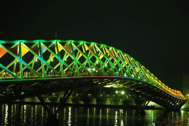A general view shows the illuminated Atal pedestrian bridge over the Sabarmati River in Ahmedabad on late May 3, 2023. (Photo by Sam Panthaky/AFP Photo)