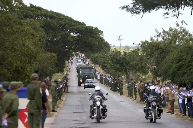 The caravan carrying the ashes of Fidel Castro pass along a highway on the way to the eastern city of Santiago, in Cardenas, Cuba, November 30, 2016. (Photo by Edgard Garrido/Reuters)