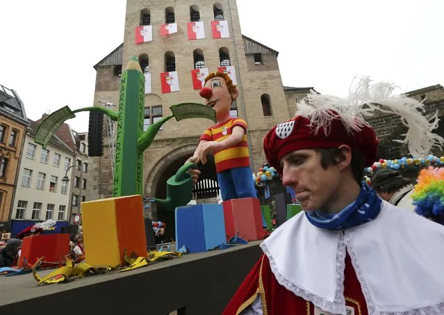Carnival revellers stand in front of a carnival float carrying papier-mache figures depicting Charlie Hebdo, during the traditional Rose Monday carnival parade in Cologne February 16, 2015. Words read “Freendom of the fools”. (Photo by Wolfgang Rattay/Reuters)
