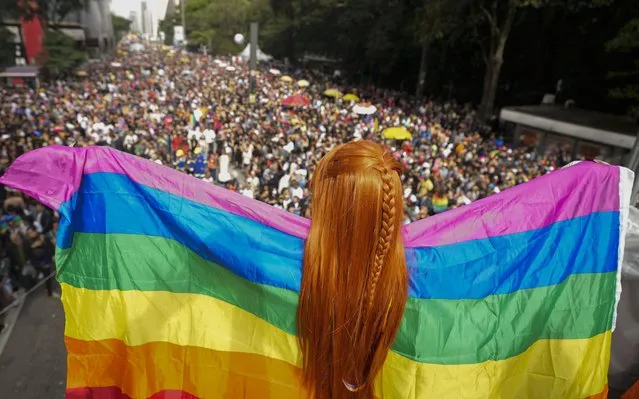 A reveller holds a rainbow flag during the annual Gay Pride Parade in Sao Paulo, Brazil, Sunday, June 19, 2022. (Photo by Andre Penner/AP Photo)