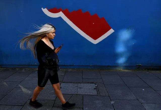 A woman walks past the symbolic remains of a Pro-Choice “Repeal the 8th Amendment” mural painted for Ireland's abortion referendum that was ordered to be removed at the time, in Temple Bar, Dublin, Ireland on March 16, 2021. (Photo by Clodagh Kilcoyne/Reuters)