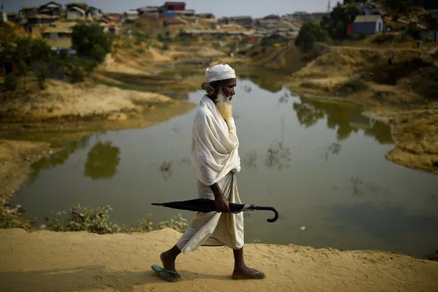 A Rohingya refugee walks with an umbrella at Jamtoli refugee camp in Cox's Bazaar, Bangladesh, March 31, 2018. (Photo by Clodagh Kilcoyne/Reuters)