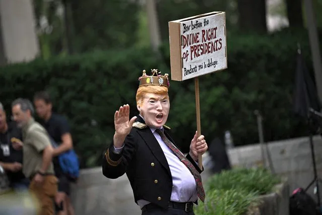 A Trump impersonator holds a sign outside the E. Barrett Prettyman US Courthouse in Washington, DC, on August 28, 2023. US District Judge Tanya Chutkan, who is overseeing the case against former US President Donald Trump over his alleged efforts to overturn the 2020 Presidential election results, is expected to set Trump's trial date for the case. (Photo by Brendan Smialowski/AFP Photo)
