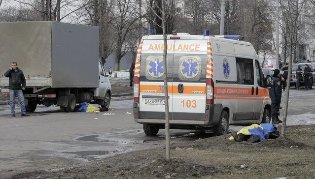 ATTENTION EDITORS - VISUAL COVERAGE OF SCENES OF INJURY OR DEATH
The bodies of victims covered by Ukrainian national flags are seen at the site of an attack in Kharkiv, February 22, 2015. At least two people were killed and 10 wounded on Sunday when an explosive device was thrown from a car into a crowd attending a peace rally in the northeastern Ukrainian city of Kharkiv, Ukrainian officials said.  REUTERS/Stanislav Belousov (UKRAINE - Tags: MILITARY CONFLICT CIVIL UNREST)