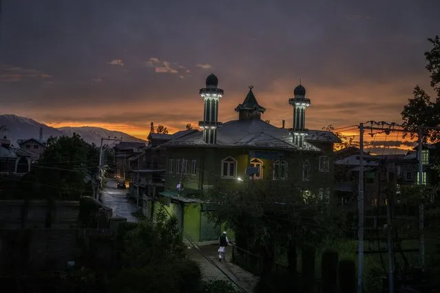 A Kashmiri Muslim walks towards a mosque during sunset in Srinagar, India, Friday, May 14, 2021. (Photo by Altaf Qadri/AP Photo)