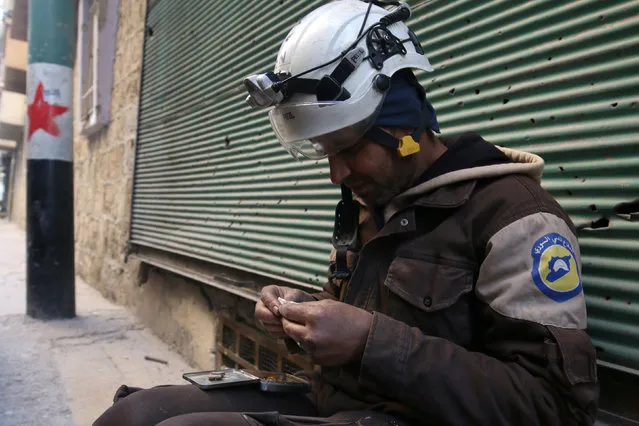 A Civil Defence member rolls a cigarette in a rebel-held area of Aleppo, Syria December 8, 2016. (Photo by Abdalrhman Ismail/Reuters)