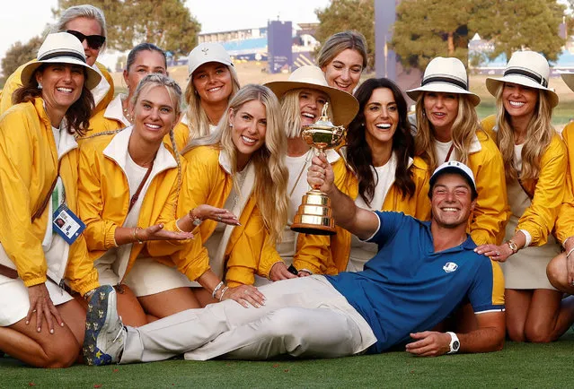 Team Europe's Viktor Hovland poses with the trophy and the partners of his teammates as they celebrate after winning the 2023 Ryder Cup in Rome, Italy on October 1, 2023. (Photo by Guglielmo Mangiapane/Reuters)
