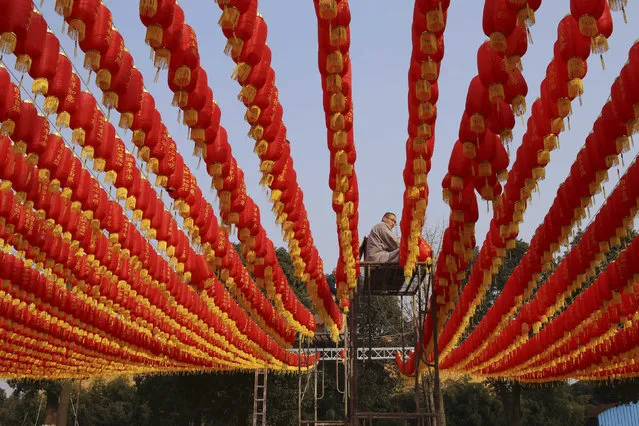A man decorates a temple with lanterns ahead of the upcoming Spring Festival in Jiaxing, Zhejiang province, February 3, 2016. (Photo by Reuters/Stringer)