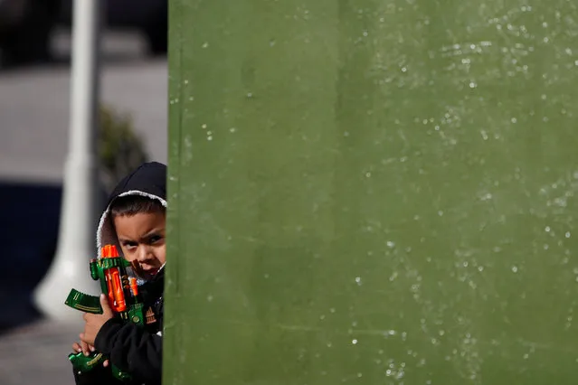 A child plays with a toy gun at a plaza in downtown Ciudad Juarez, Mexico, December 5, 2016. (Photo by Jose Luis Gonzalez/Reuters)