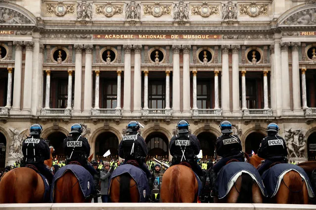 Mounted French police face off with protesters wearing yellow vests as they form a line on horses in front of the Opera House as part of the “yellow vests” movement in Paris, France, December 15, 2018. (Photo by Christian Hartmann/Reuters)