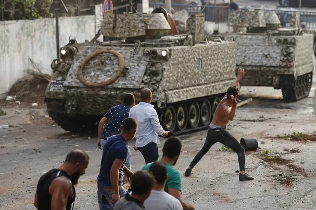Supporters of Prime Minister-designate Saad Hariri who stepped down on Thursday clash with Lebanese soldiers in Beirut, Lebanon, Thursday, July 15, 2021. Hariri says he is stepping down, nine months after he was named to the post by the parliament. He is citing “key differences” with the country's president, Michel Aoun. (Photo by Hussein Malla/AP Photo)