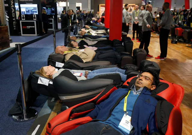 CES attendees take a break on Inada DreamWave massage chairs during the 2017 CES in Las Vegas, Nevada, U.S., January 6, 2017. (Photo by Steve Marcus/Reuters)