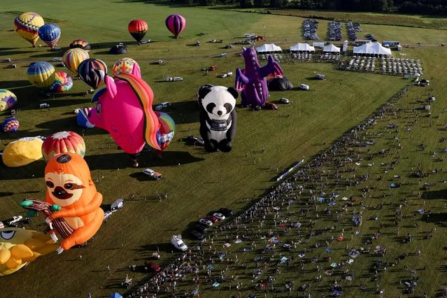 People enjoy a balloon ride during the New Jersey Lottery Festival of Ballooning in Readington, New Jersey, U.S., July 24, 2021. (Photo by Hannah Beier/Reuters)