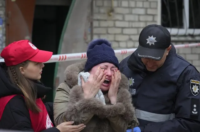 A woman is comforted by servicemen as she cries at the scene of night shelling in Mykolaiv, Ukraine, Friday, November 11, 2022. (Photo by Efrem Lukatsky/AP Photo)