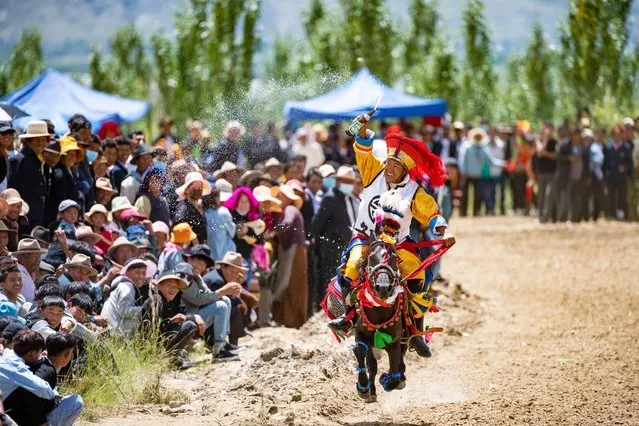 A rider sprays spectators with beer on August 26, 2021 during a horse race in Gangdan Village of Gonggar County, Southwest China's Tibet Autonomous Region – an administrative area which covers about half the area of “historic” Tibet. An annual horse racing event was held here on Thursday to celebrate the upcoming harvest season. (Photo by Chine Nouvelle/SIPA Press/Rex Features/Shutterstock)