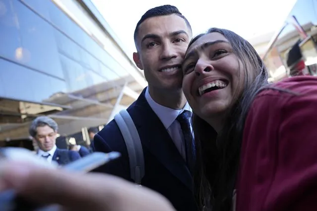 Portugal's Cristiano Ronaldo poses for a photo with Giuliana, a fan from Brazil, as he arrives with the Portuguese team at Lisbon airport to depart for the World Cup in Qatar, Friday, November 18, 2022. (Photo by Armando Franca/AP Photo)