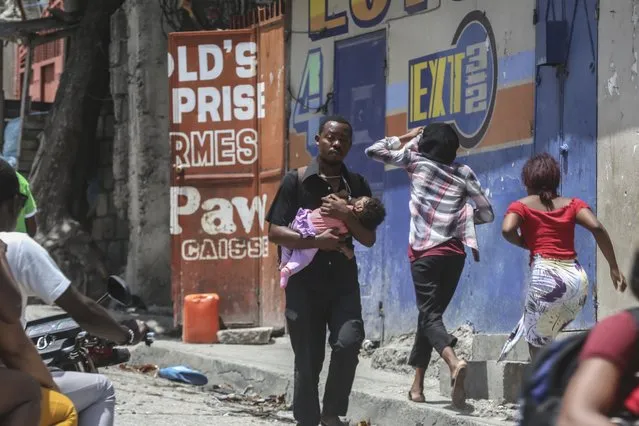 Residents flee their homes to escape clashes between armed gangs in the Carrefour-Feuilles district of Port-au-Prince, Haiti, Tuesday, August 15, 2023. (Photo by Odelyn Joseph/AP Photo)