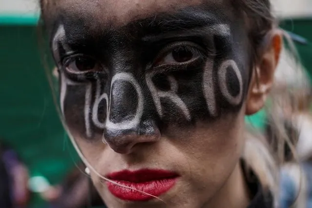 A demonstrator takes part in a rally in support of legal and safe abortion during a march to mark the International Safe Abortion Day in Bogota, Colombia on September 28, 2021. The letters painted on her face read “Abortion”. (Photo by Nathalia Angarita/Reuters)