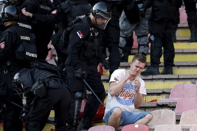 An injured Red Star Belgrade fan sits during clashes with riot police in the stadium before their Serbian Superliga soccer match against Partizan Belgrade in Belgrade, April 25, 2015. (Photo by Marko Djurica/Reuters)