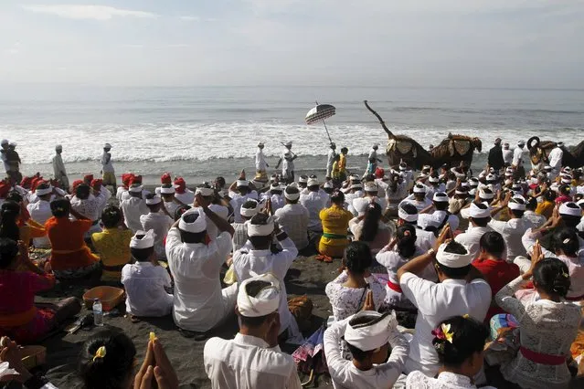 Balinese Hindu worshippers pray on the beach during Melasti, a purification ceremony, ahead of the holy day of Nyepi, in Gianyar on the Indonesian resort island of Bali, March 6, 2016. (Photo by Roni Bintang/Reuters)