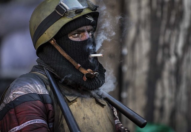 An anti-government activist armed with chainsticks smokes a cigarette at a barricade in central Kiev, on January 31, 2014. Ukraine's embattled president Viktor Yanukovych is taking sick leave as the country's political crisis continues without signs of resolution. (Photo by Darko Bandic/Associated Press)