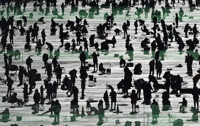 Anglers fish through holes on a frozen river during the annual ice fishing festival in Hwacheon on January 7, 2024. (Photo by Jung Yeon-je/AFP Photo)