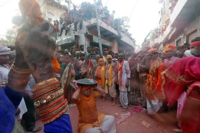 A man shields himself from a woman beating him with a stick during “Lathmar Holi” celebrations in the town of Barsana, in Uttar Pradesh, India, March 15, 2019. (Photo by Altaf Hussain/Reuters)