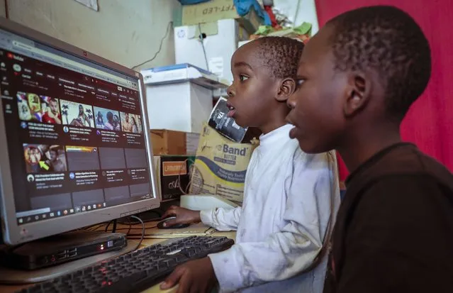 Two young boys use a computer at an internet cafe in the low-income Kibera neighborhood of Nairobi, Kenya Wednesday, September 29, 2021. Instead of serving Africa's internet development, millions of internet addresses reserved for Africa have been waylaid, some fraudulently, including in insider machinations linked to a former top employee of the nonprofit that assigns the continent's addresses. (Photo by Brian Inganga/AP Photo)