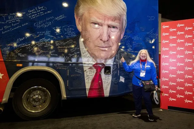 A volunteer poses for a photo with a bus featuring former President Donald Trump’s face, at the Conservative Political Action Conference (CPAC) annual meeting in National Harbor, Maryland, U.S., February 22, 2024. (Photo by Amanda Andrade-Rhoades/Reuters)