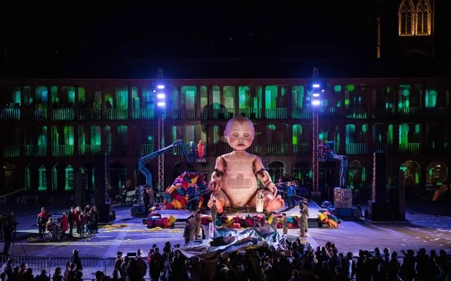 Actors perform the world premiere of the outdoor theatre production ZARA, around a giant mechanical moving baby named Eva, at the Piece Hall in Halifax, northern England on April 19, 2019. The performance features a cast of over 100 actors telling the story of a learning disabled mother and her fight to protect her baby. (Photo by Oli Scarff/AFP Photo)
