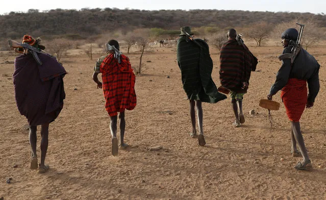 Turkana tribesmen walk with guns in order to protect their cattle from rival Pokot and Samburu tribesmen near Baragoy, Kenya February 14, 2017. (Photo by Goran Tomasevic/Reuters)