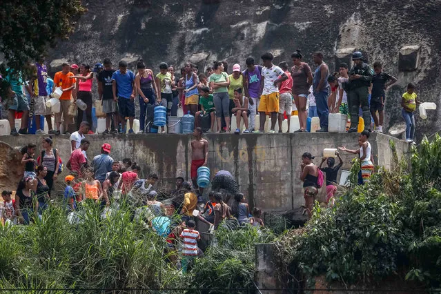People collect water in Catia neighborhood, in Caracas, Venezuela, 01 April 2019. In addition to the blackout in part of the country, people have been affected by water scarcity. (Photo by Miguel Gutiérrez/EPA/EFE)