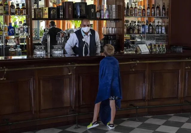 A young tourist asks a waiter for a soft drink at the Iberostar Selection Varadero hotel in Varadero, Cuba, Wednesday, September 29, 2021. (Photo by Ramon Espinosa/AP Photo)