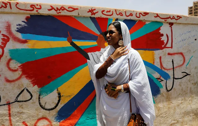 Alaa Salah, a Sudanese protester whose video gone viral and make her an icon for the mass anti-government protests, stands in front of a mural depicting her in front of the Defence Ministry in Khartoum, Sudan, April 20, 2019. (Photo by Umit Bektas/Reuters)