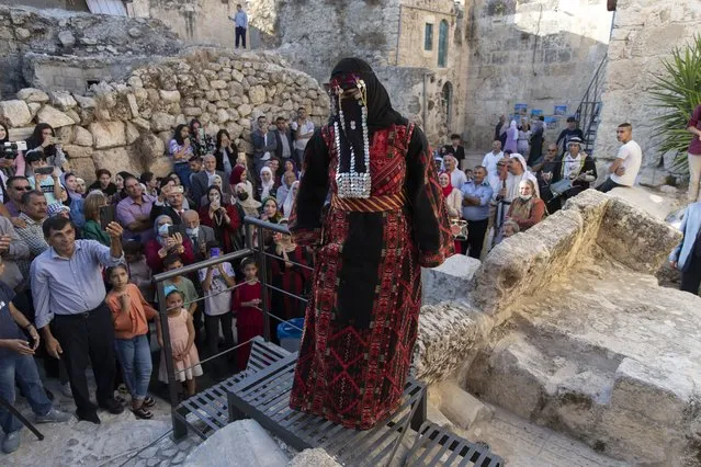 A model wears a traditional Palestinian dress during a show in the Palestinian Heritage day, at the historic archaeological center of the West Bank village of Sebastia, north of Nablus, Thursday, October 7, 2021. (Photo by Nasser Nasser/AP Photo)