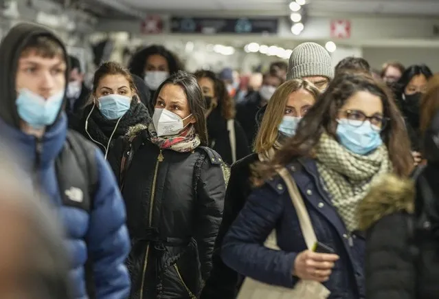 Commuters wearing face masks to protect against COVID-19 while walking through the La Defense business district transportation hub in Paris, Wednesday, December 8, 2021. The new potentially more contagious omicron variant of the coronavirus popped up in more European countries just days after being identified in South Africa, leaving governments around the world scrambling to stop the spread. (Photo by Michel Euler/AP Photo)