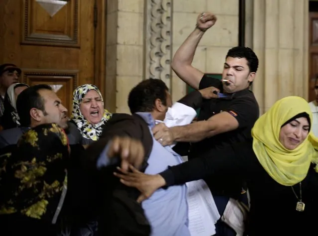 Supporters of Egypt's ousted President Hosni Mubarak clash with a lawyer representing protestors who were killed during the Jan. 25th uprising, after a trial session at the Cairo High Court in Egypt, Thursday, April 7, 2016. Mubarak is being retried over the killing of hundreds of protesters during the 2011 uprising that ended his nearly three decades in power. (Photo by Amr Nabil/AP Photo)
