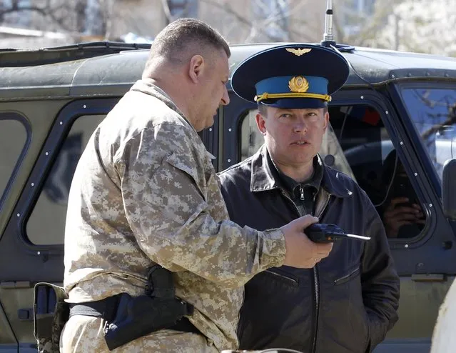 A Russian military officer (L) talks to Ukrainian Colonel Yuli Mamchur (L), demanding Ukrainian servicemen leave a military base in the Crimean town of Belbek near Sevastopol March 22, 2014. (Photo by Vasily Fedosenko/Reuters)
