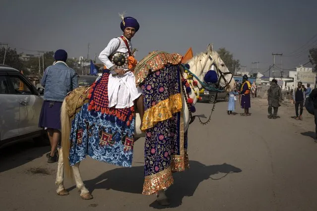 A Nihang or a Sikh warrior rides his decorated horse as farmers start vacating the protest site in Singhu, on the outskirts of New Delhi, India, Saturday, December 11, 2021. (Photo by Altaf Qadri/AP Photo)