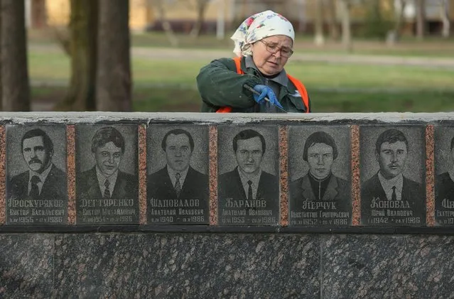 A worker renovates a memorial to technicians who died during and in the immediate aftermath of the Chernobyl nuclear accident, April 8, 2016, in Slavutych, Ukraine. (Photo by Sean Gallup/Getty Images)