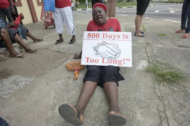 A member of Bring Back Our Girls movement csits on the ground with a plarcard as she and others press for the release of the missing Chibok schoolgirls in Lagos, on April 14, 2016. Nigeria's government said it was studying a “proof of life” video showing 15 of the more than 200 schoolgirls abducted by Boko Haram, as parents and their supporters marked the second anniversary of the kidnapping. A total of 276 girls were abducted from the Government Girls Secondary School in Chibok, northeast Nigeria, on April 14, 2014. Fifty-seven escaped in the immediate aftermath. (Photo by Pius Utomi Ekpei/AFP Photo)