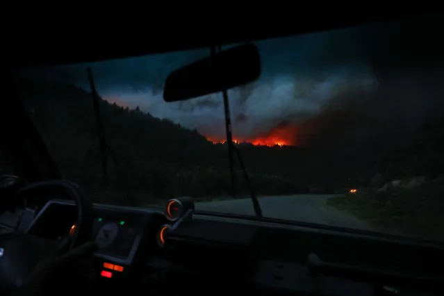 View of a huge fire from the Route 40 in Paraje Villegas, Rio Negro province, 70 km south of Bariloche, Argentina, on December 29, 2021. Several sources of fire have been active for weeks in the Argentine provinces of Neuquen, Rio Negro and Chubut (south), where the flames have consumed thousands of hectares of native forest, amid adverse weather conditions, according to the authorities. (Photo by Francisco Ramos Mejía/AFP Photo)